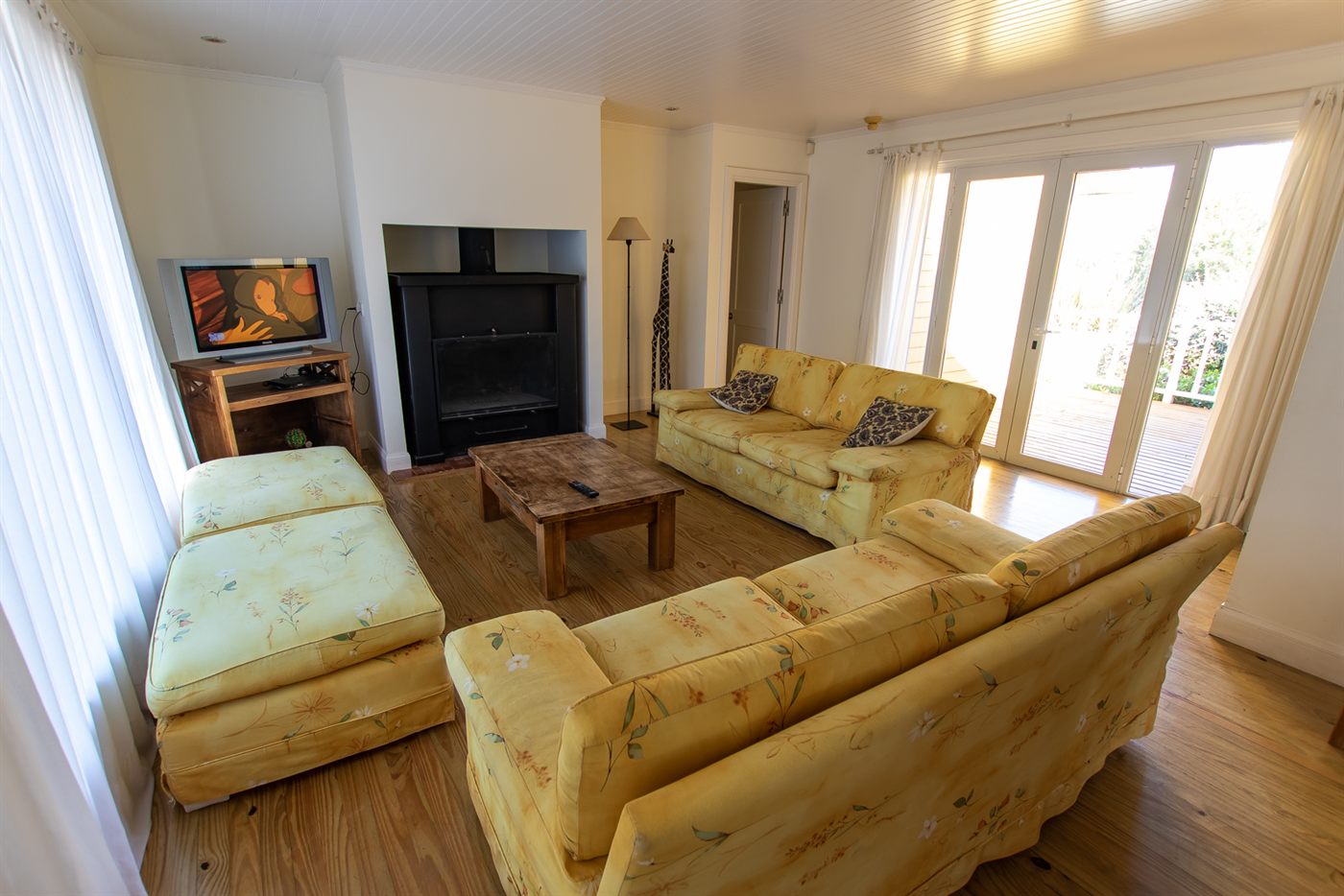 Living de la Casa Amarilla con sillones amarillos y hogar