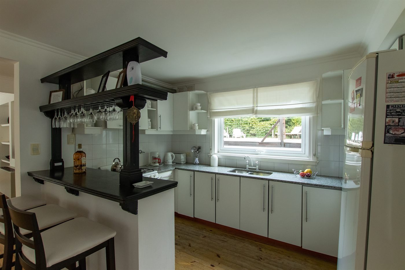 Cocina con la barra y las copas colgadas