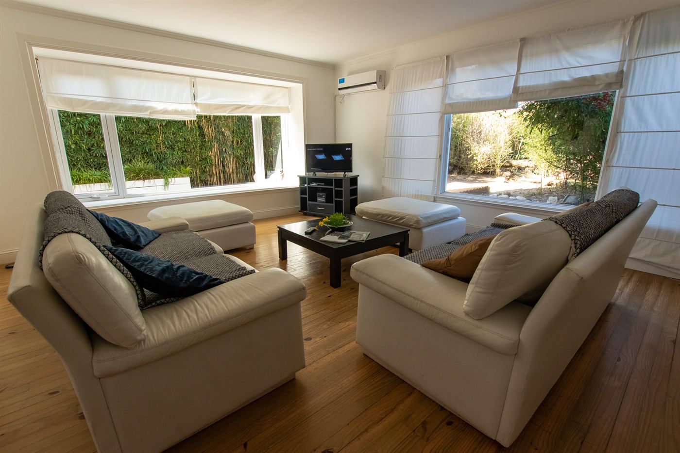 Living de la Casa Blanca con sillones beige y ventanal